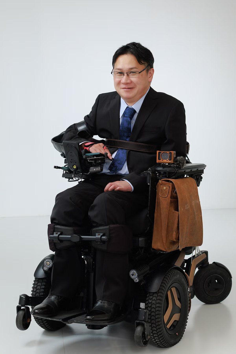 WEVENRY代表・堀内宗喜。電動車椅子に乗ったスーツ姿のポートレート